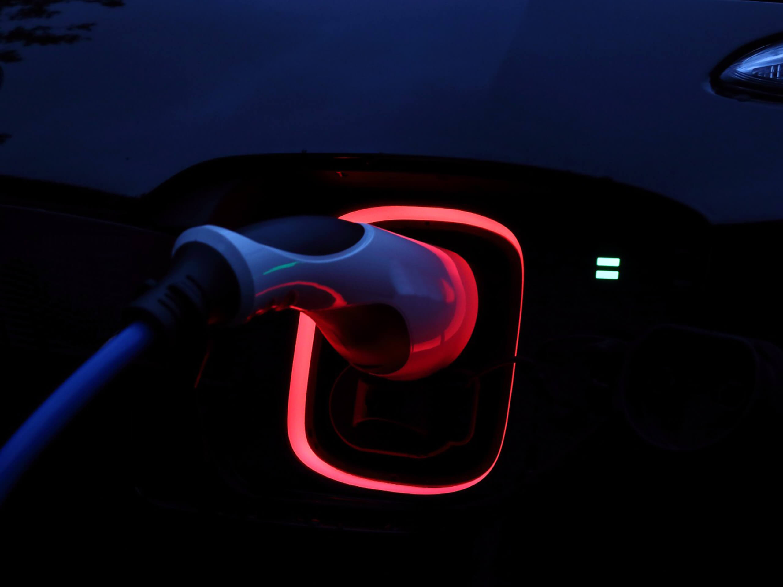 Closeup image of an electric vehicle plugged in and charging, illustrating the practicality of business energy resources.