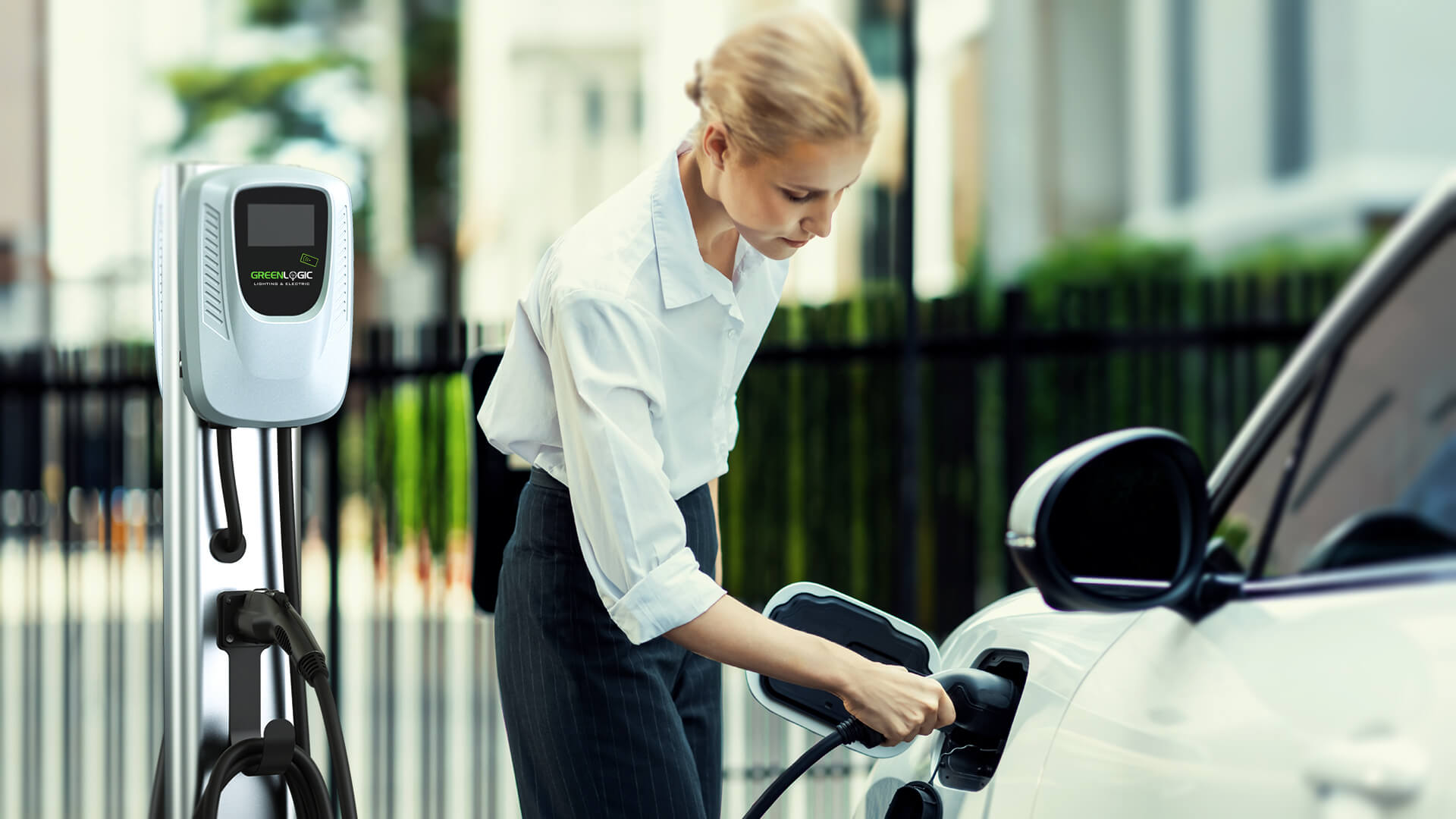 Modern business woman plugging in her car to a Greenlogic EV chargier. The image showcases the convenience and ease of use of Greenlogic's EV Charging Stations.