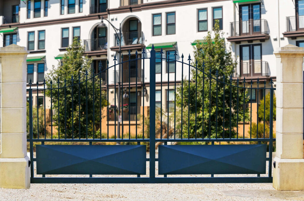 Image of a beautifully crafted metal fabrication gate at the entrance of a multifamily residential community, showcasing the quality and security of Greenlogic metal fabrication and welding services.