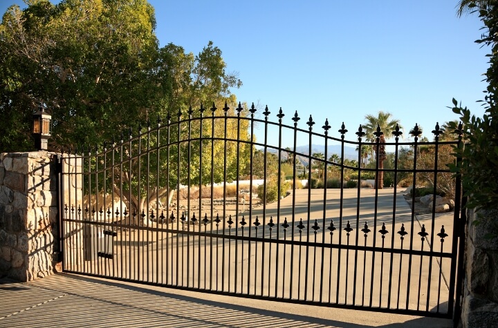 Image of a metal gate entrance to a residential community, showcasing Greenlogic's expert metal fabrication and welding services. The gate's intricate design and sturdy construction reflect our commitment to quality and security.